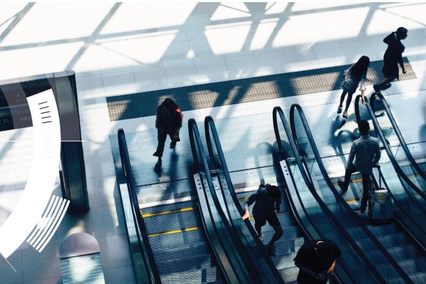 Top-angle view of people using an escalator in a commercial building