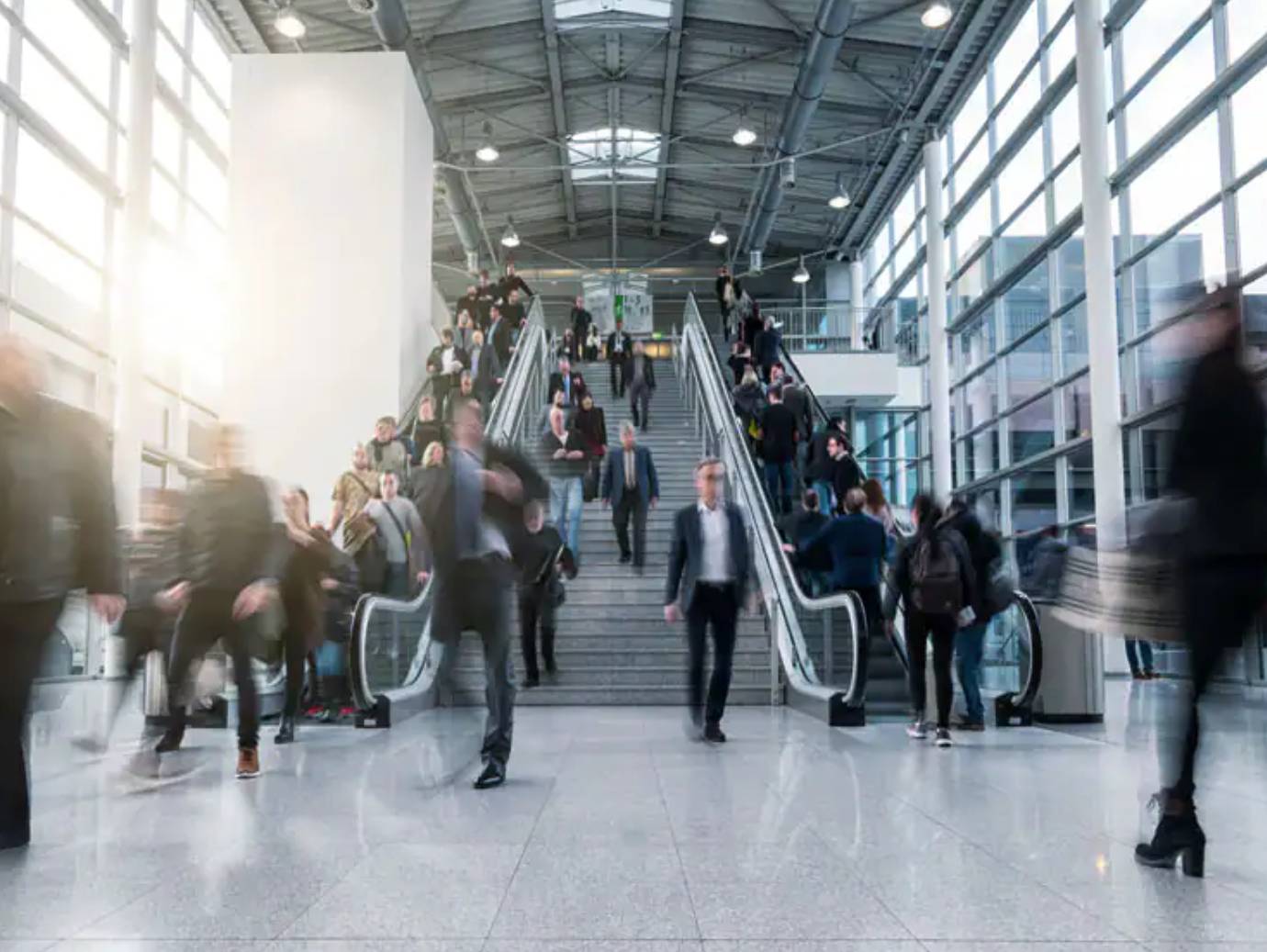 People going down an escalator and walking in a commercial building