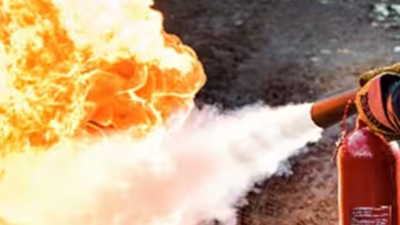 A firefighter using a fire extinguisher to put out a fire