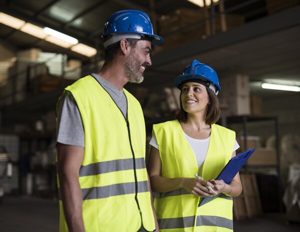 man woman conversing in warehouse