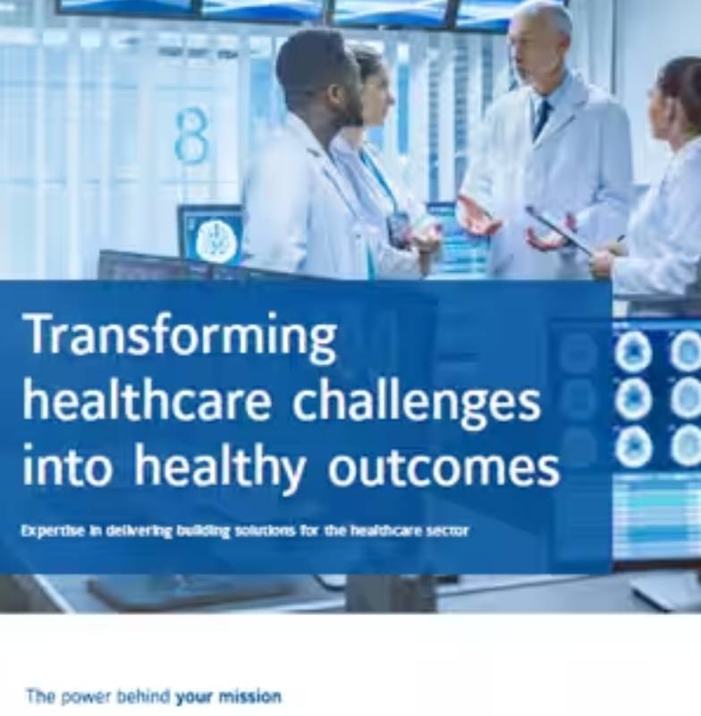 A group of doctors discussing in an operating room, with a block of text reading Transforming healthcare challenges into healthy outcomes, overlaid in the middle