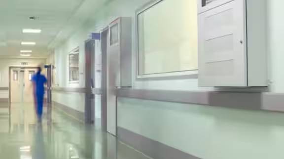 A nurse walking along a hospital passage