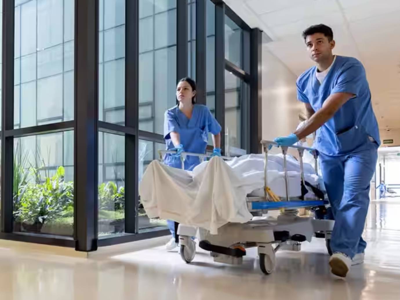 A pair of nurses carrying a patient on a stretcher in a hospital