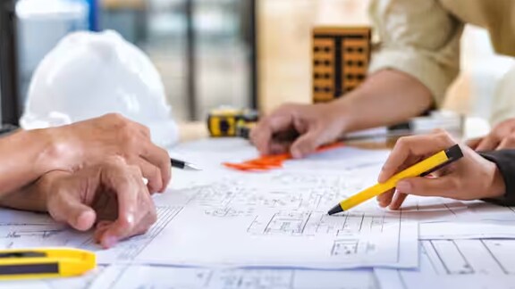 Close-up of a group of architects studying blueprints
