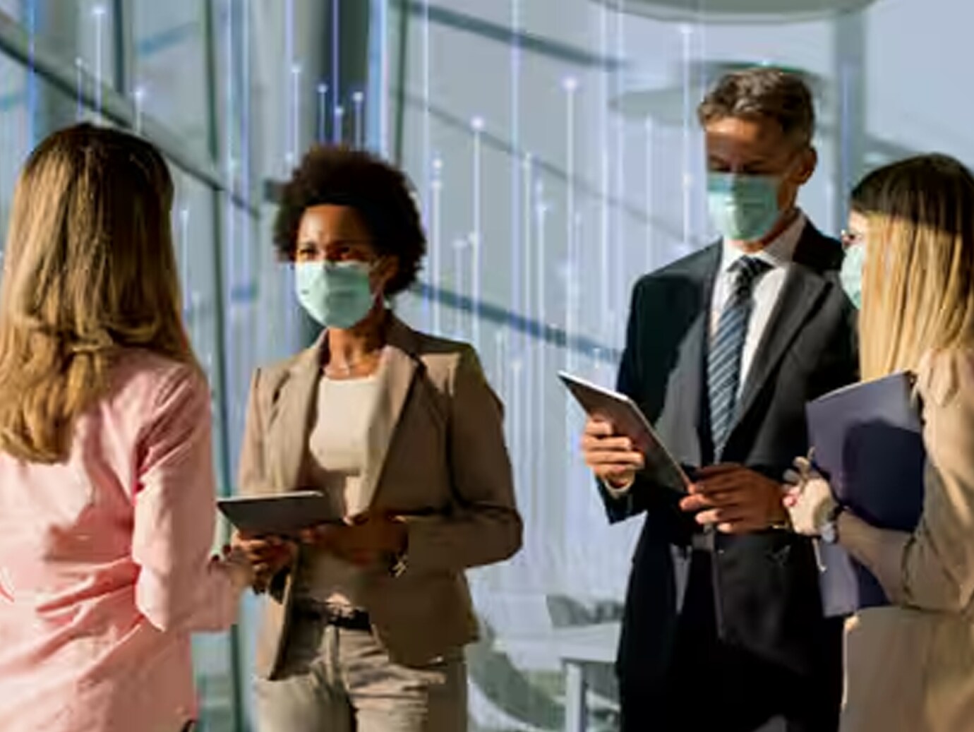 A group of colleagues wearing face masks, engaged in discussion