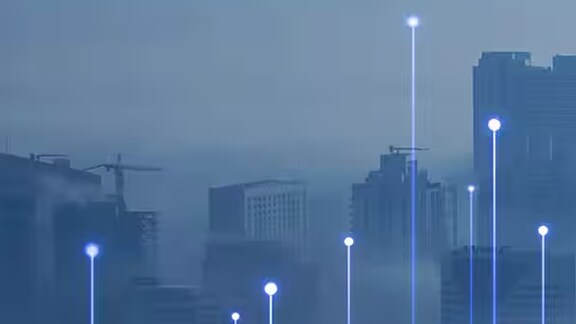 A city skyline swathed in fog, overlaid with OpenBlue graphics