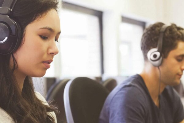 Two people working on computers in office