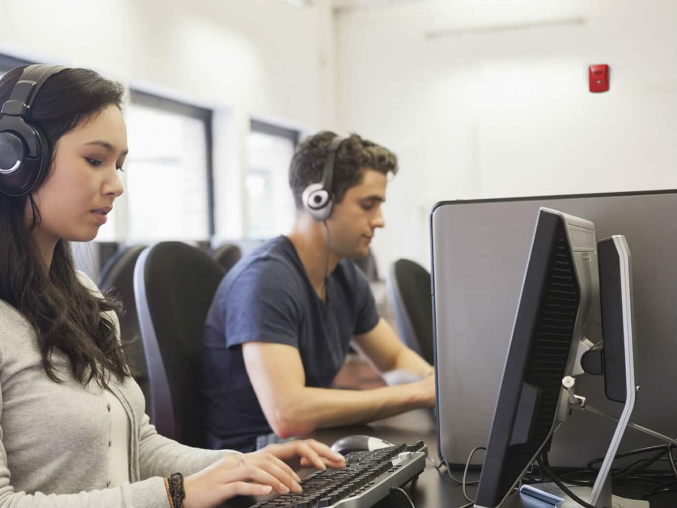 A man and woman collaborating on a computer.