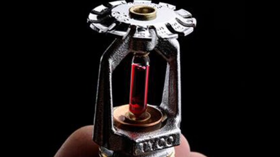 person holding a fire sprinkler equipment