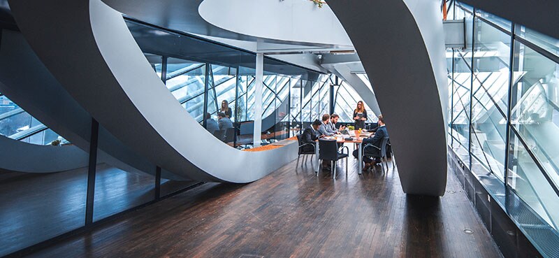 Interior of an office, where a group of employees are seated a table