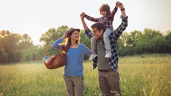 A family out for a picnic in an open green field
