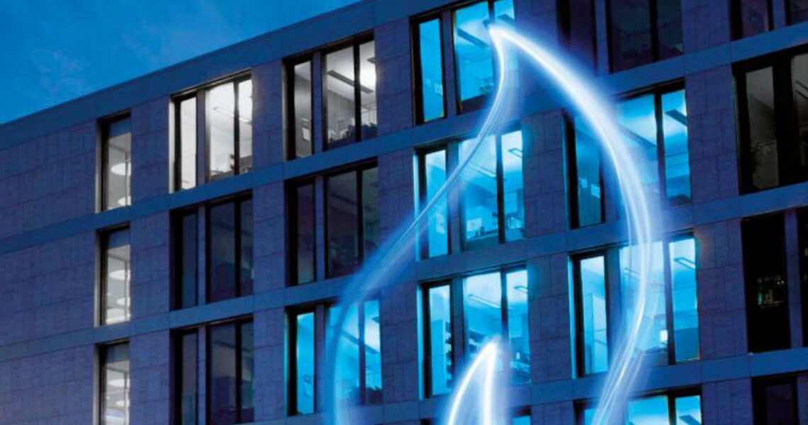 A glass statue of a flame in front of a building during night time