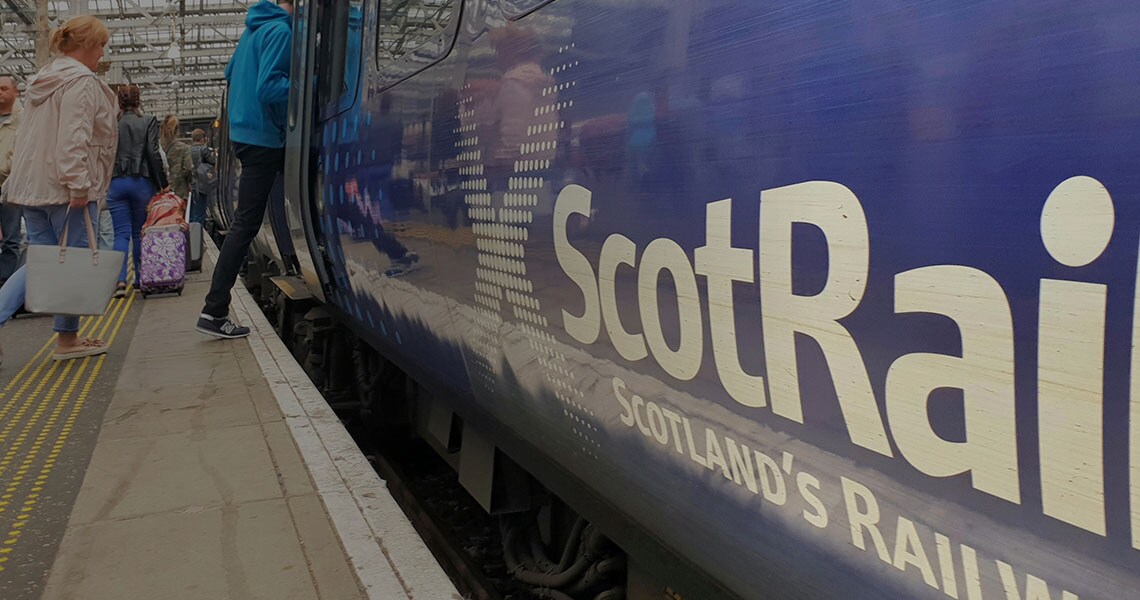 People on a train platform and a ScotRail train