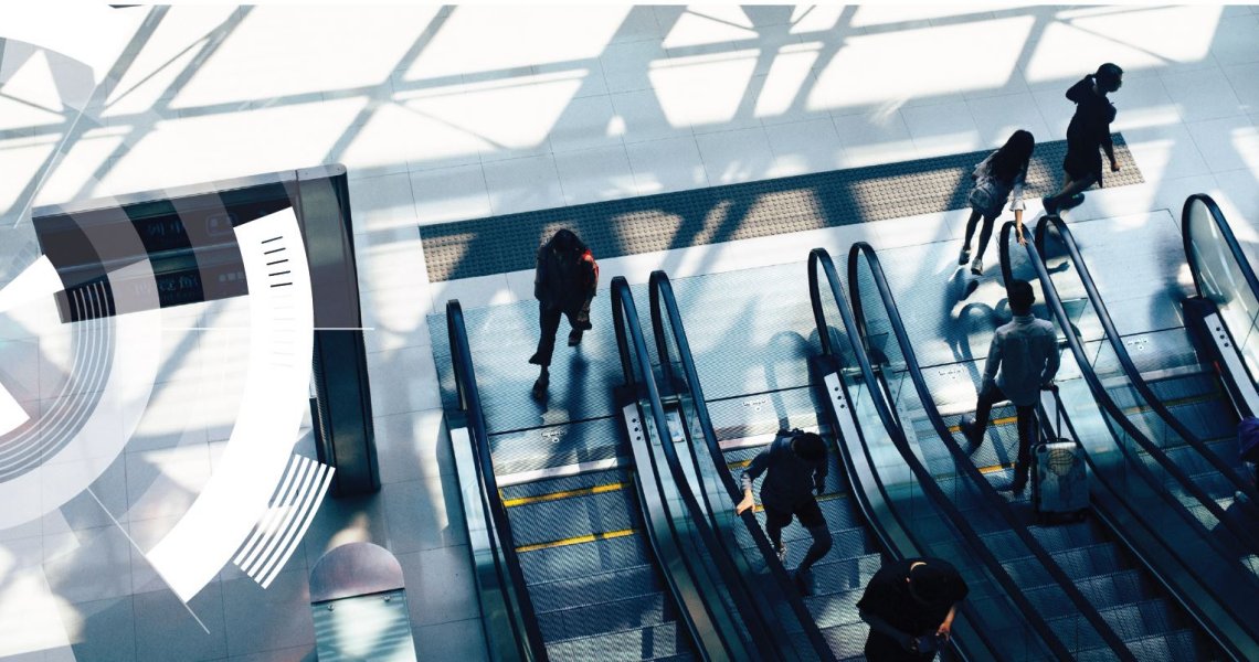 Looking down at two pairs of escalators and people using them