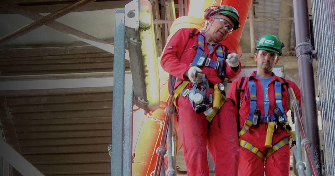 Two people in safety gear walking down the stairs