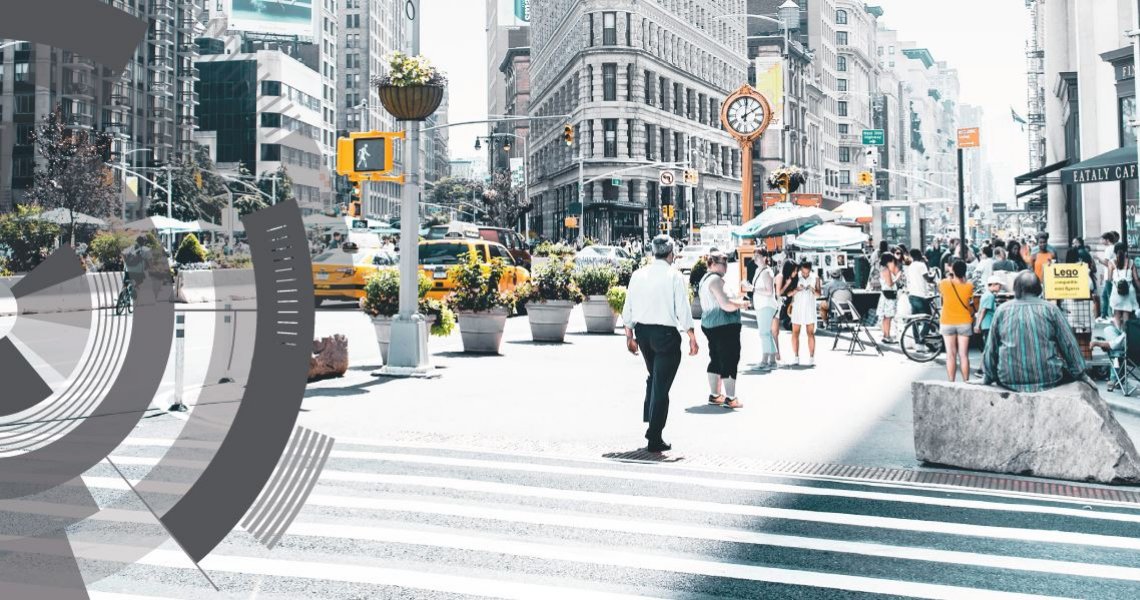 A city street with a crowded sidewalk with circular graphics