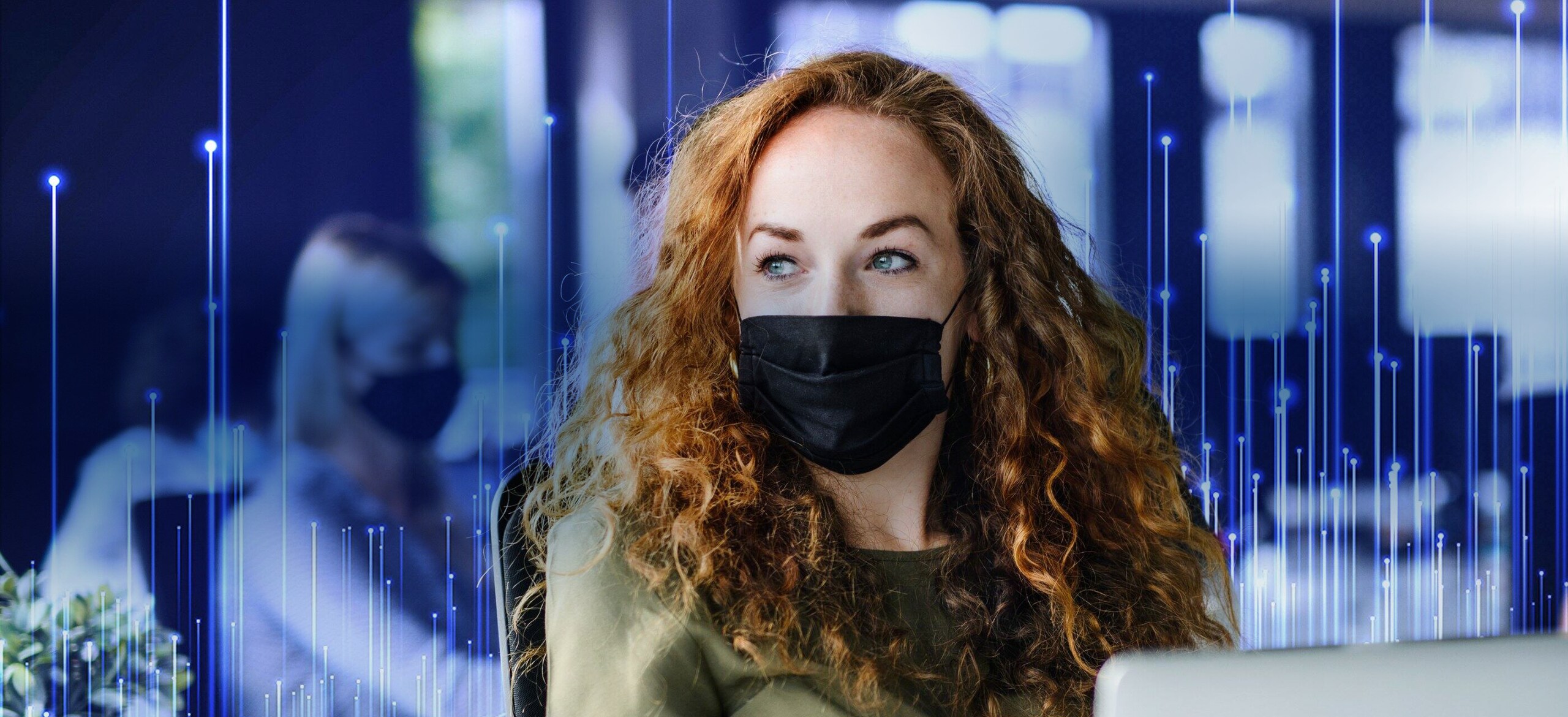 Lady wearing a black mask working in office with a network communication graphic overlaid on the background