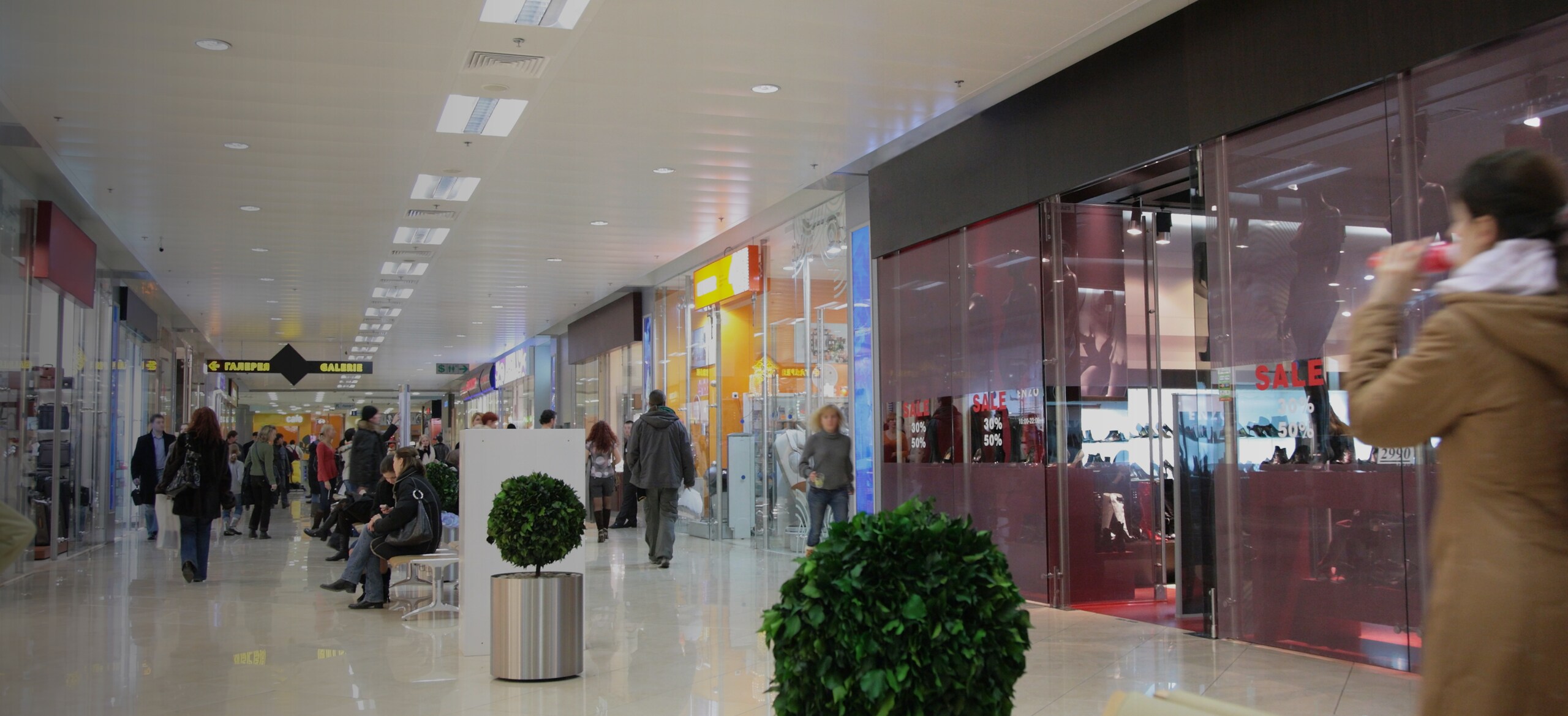 People moving along shop windows in the mall