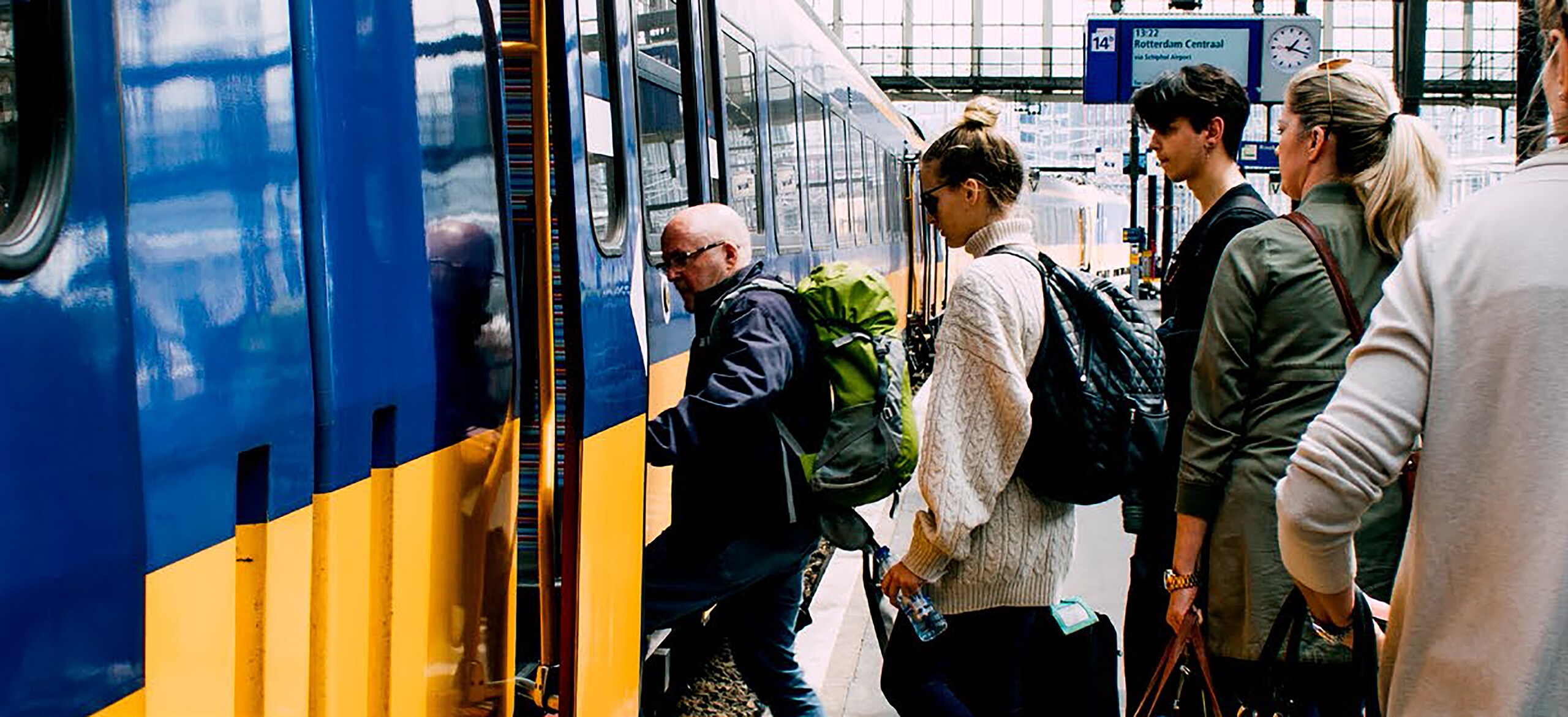 People standing in a queue to climb a train