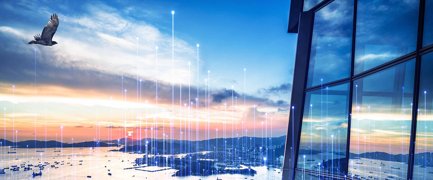 A bird flying outside a glass building along a coast with modern graphics