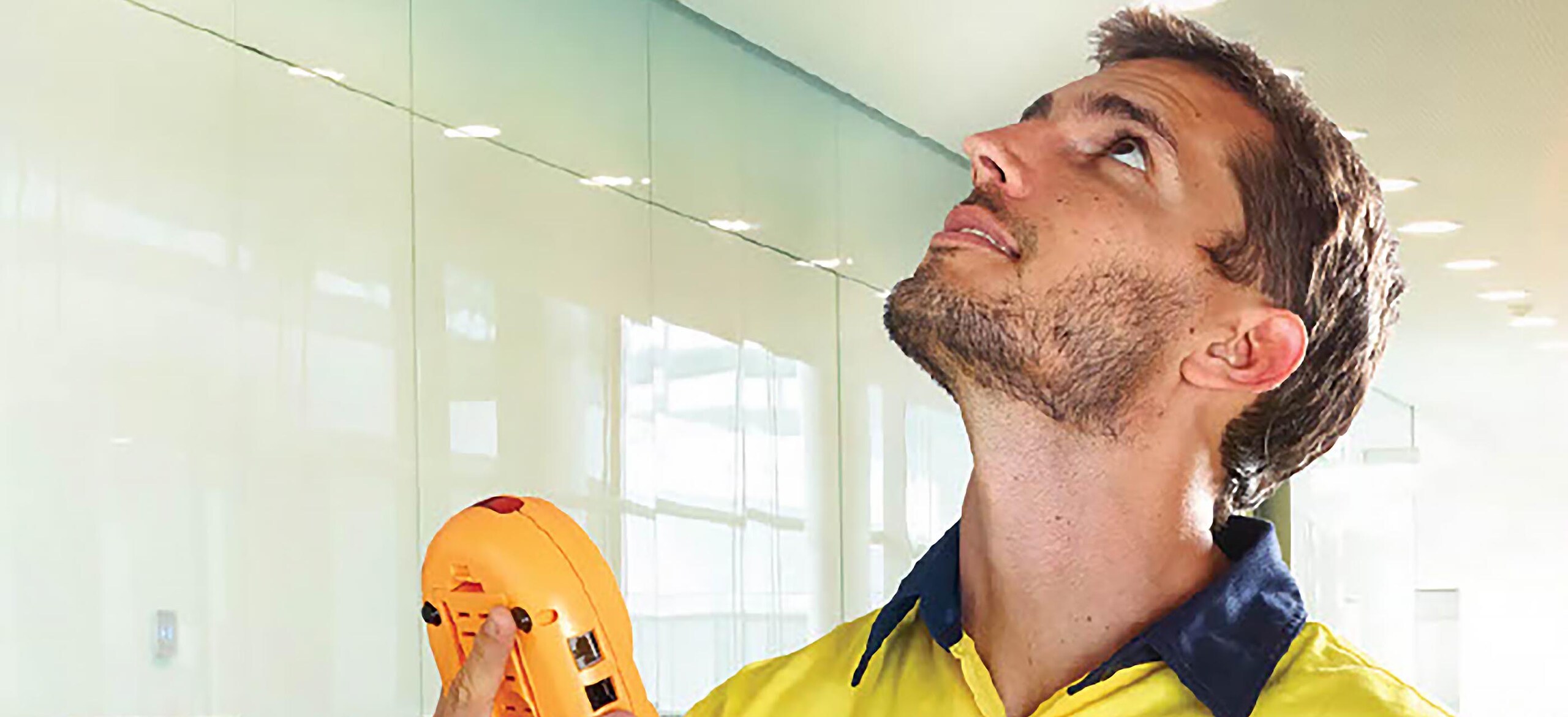 A man looking up with a remote in his hand