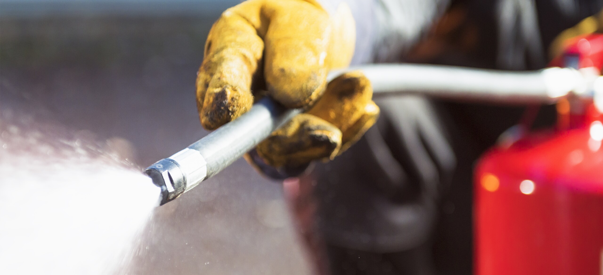 Close-up shot of a firefighter using a fire extinguisher
