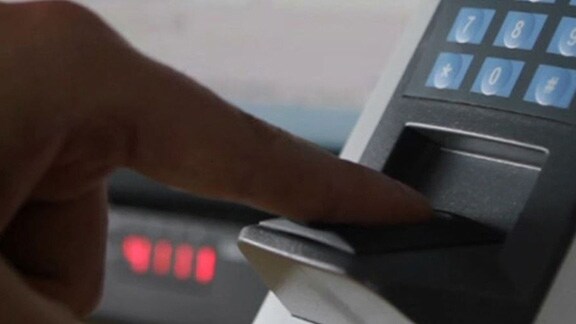 Close-up of a man scanning his finger on a biometric control