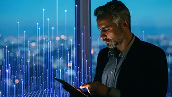 A man working on his smartphone against a window with an overlay of openblue graphics