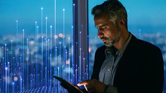 A man working on his smartphone against a window with an overlay of openblue graphics
