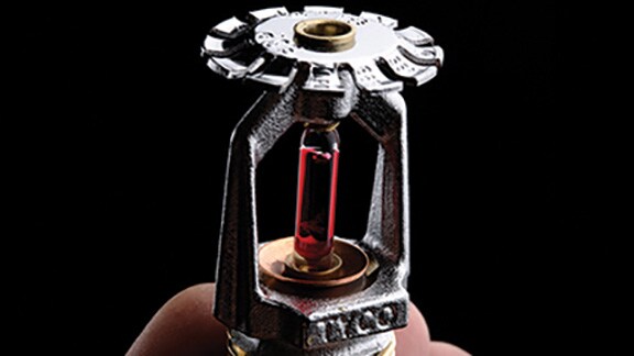 Close-up of a person holding a fire sprinkler head