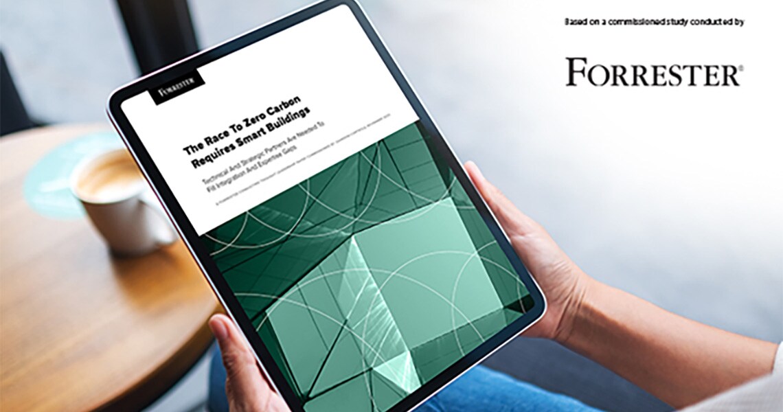 A person seated in an armchair, holding a tablet displaying a commissioned study by Forrester.