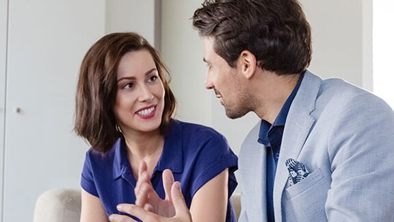 Two people on a couch having a conversation