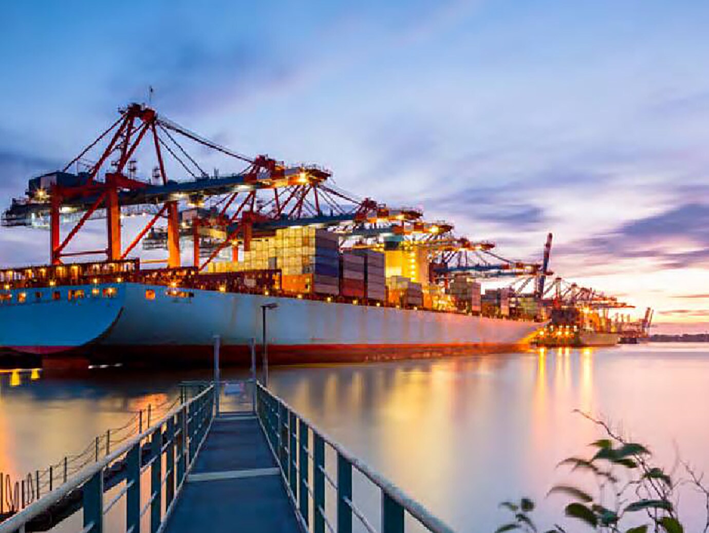 View of a cargo ship against the sunset from a pier