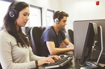 A man and a woman working on computers in an office