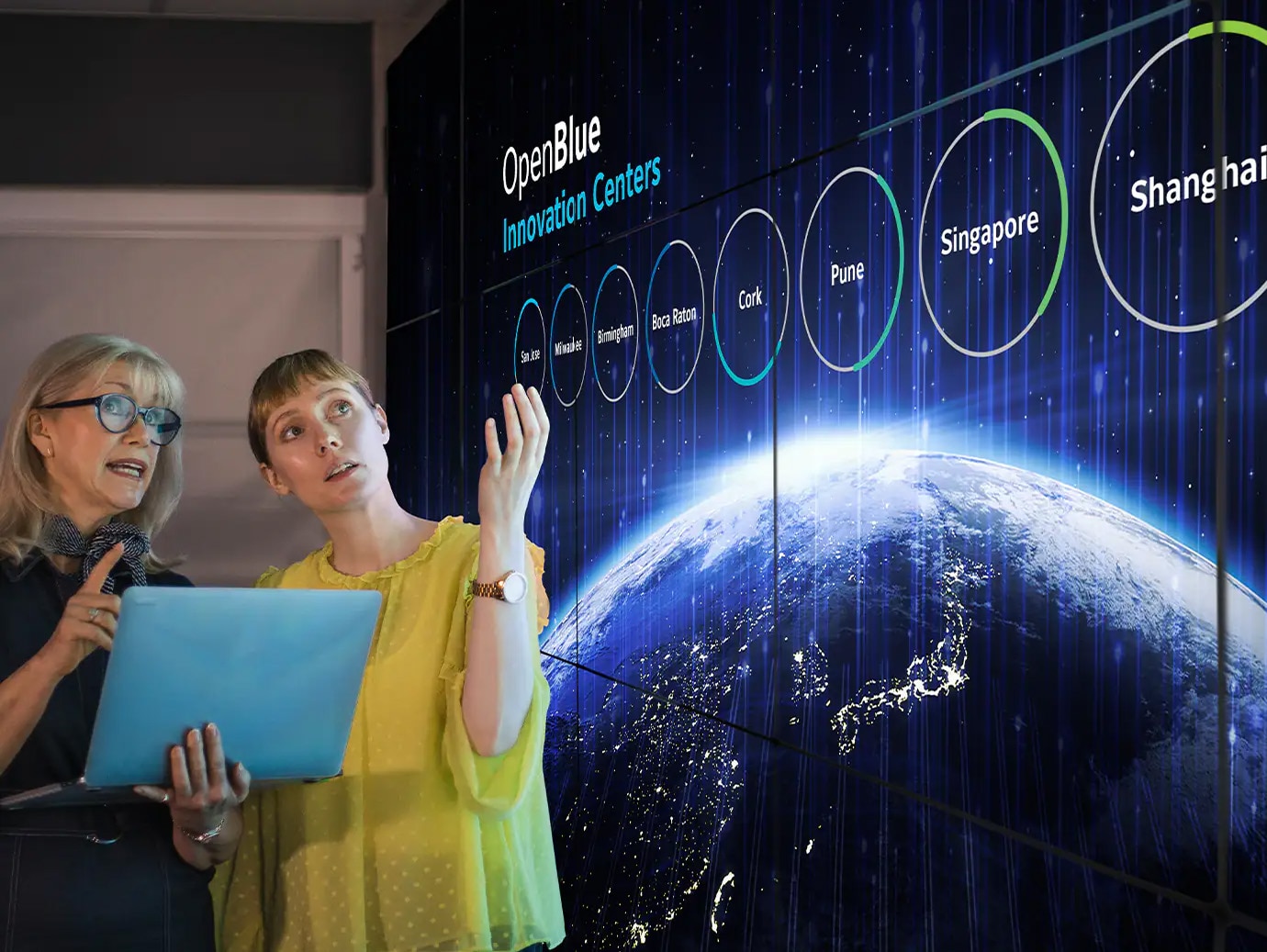 Two women discussing a presentation on OpenBlue Innovation Centers