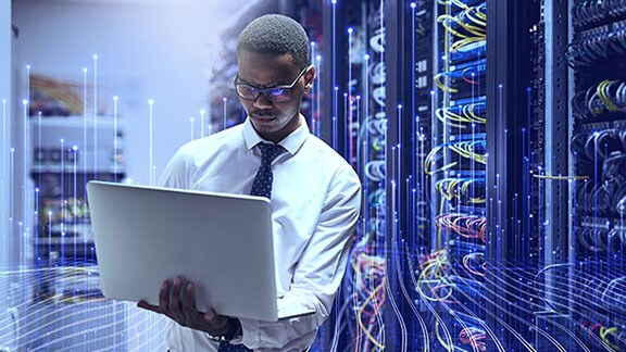 Man holding a laptop in datacenter