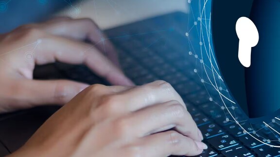 hands on laptop operating with security graphic