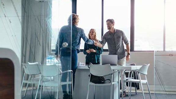 employees shaking hands with client