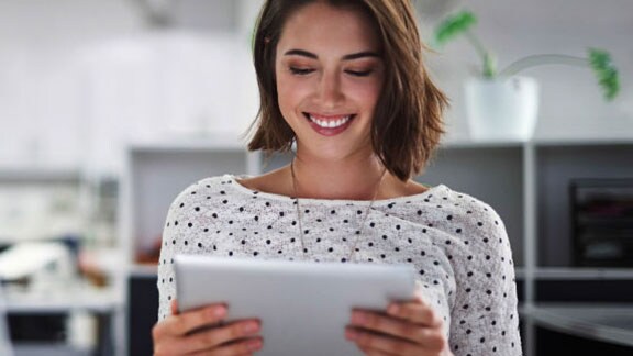 woman smiling using tablet