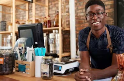 smiling barista leaning on counter