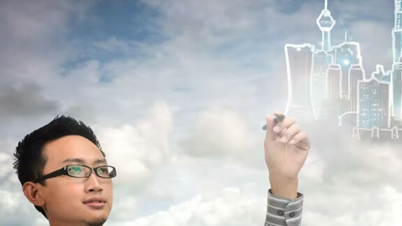 Man drawing cityscape on screen.