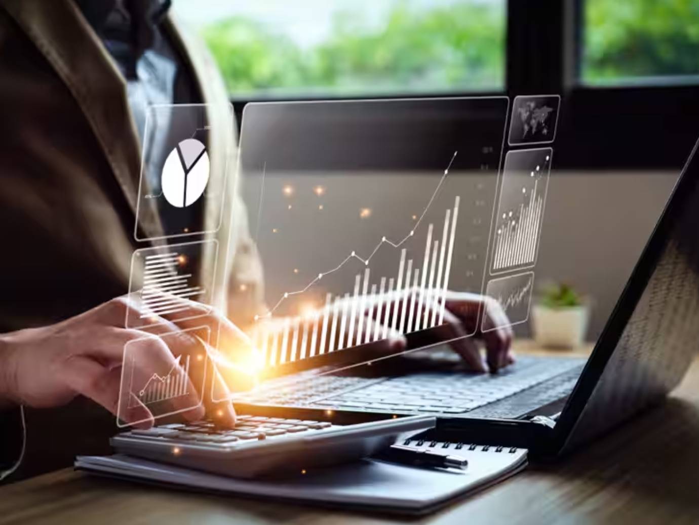 Close-up of a businessman working on a laptop, surrounded by graphics depicting technology