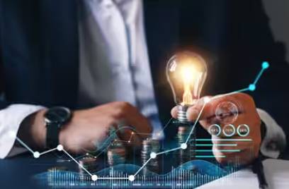 Close-up of a businessman holding a lightbulb, surrounded by graphics depicting technology and progress