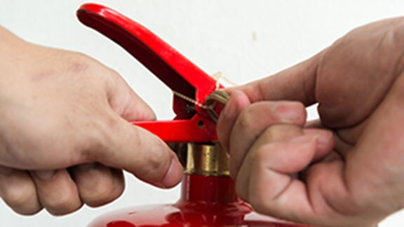 Hand presses the trigger fire extinguisher