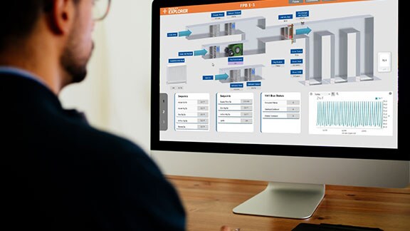 a man sitting infront of monitor screen