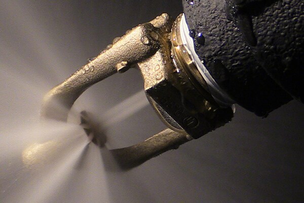 A fire sprinkler sprinkling water at a high pressure