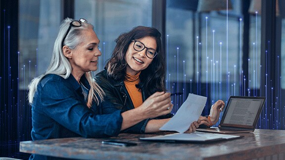 Two women sitting a table and discussing paperwork