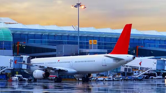 Airplanes gathered on the runway outside the airport terminal on a rainy day