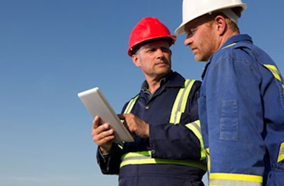 workers discussing holing tablet