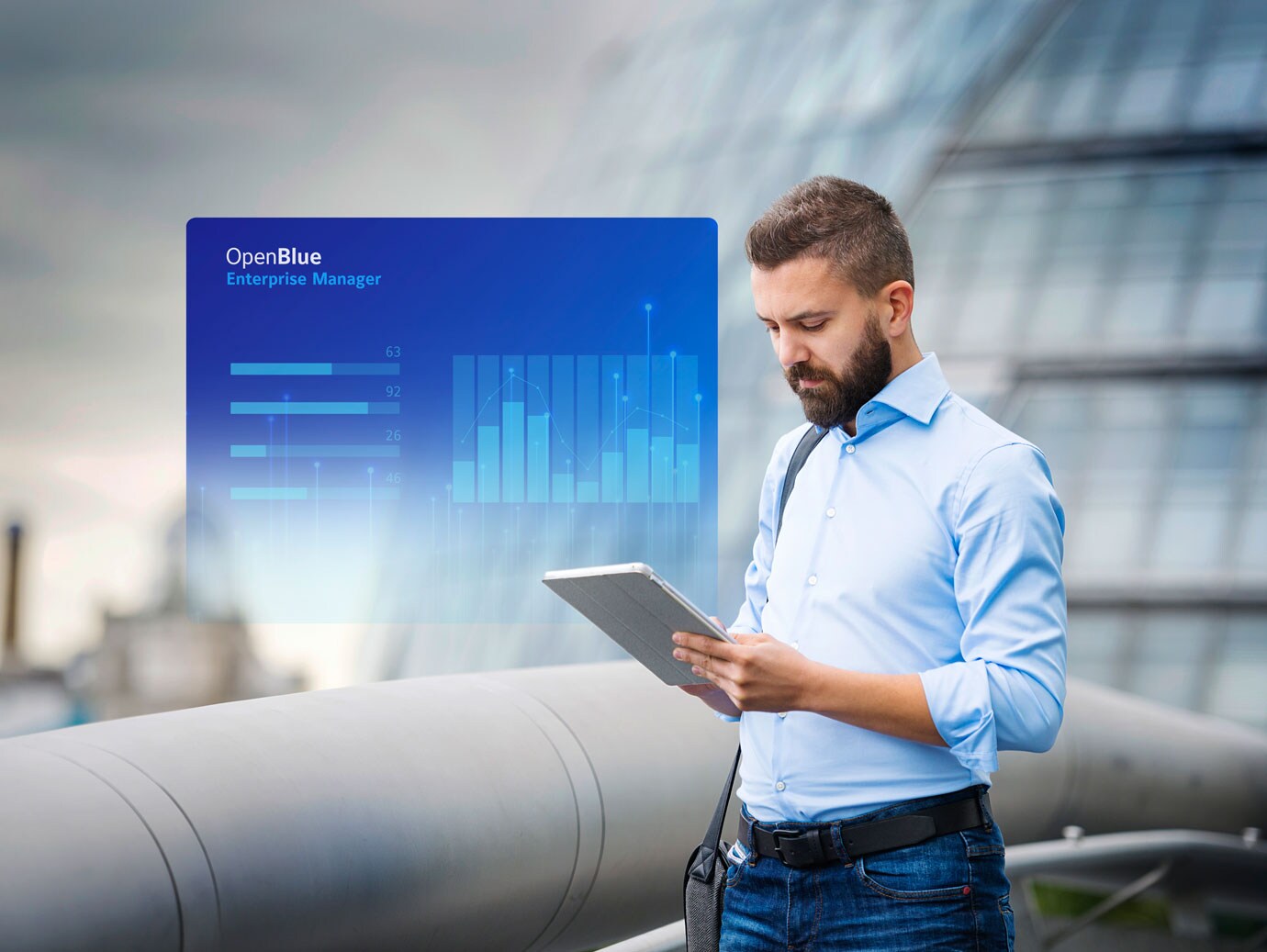 Man looking at a tablet screen with an overlaid image of OpenBlue Enterprise Manager window on the background